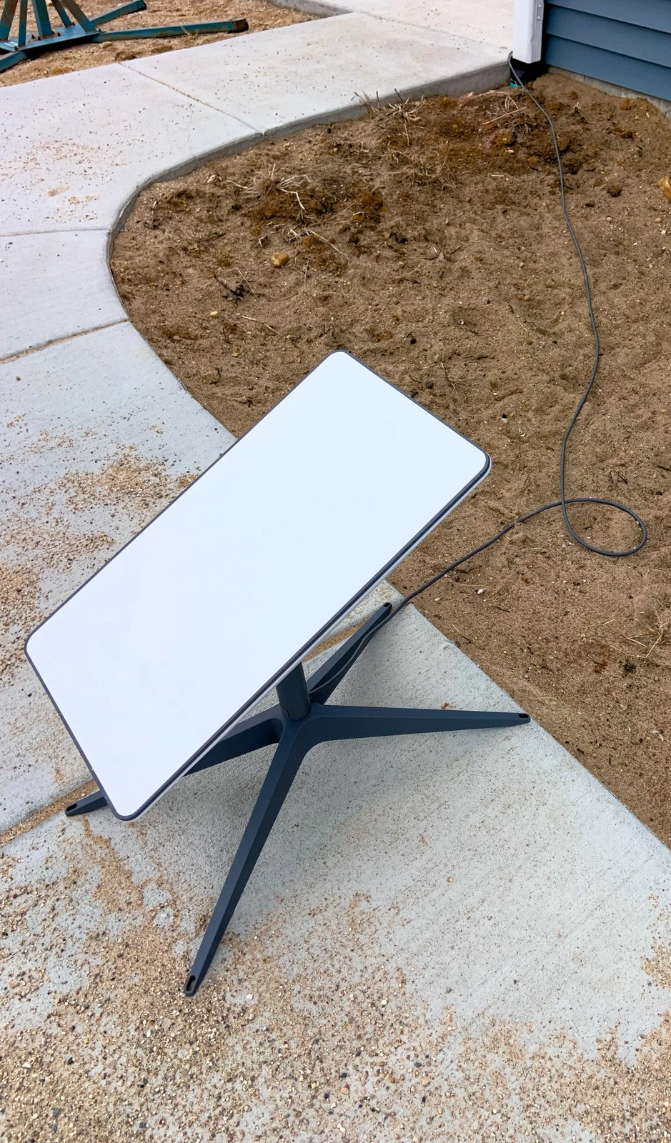 An actual rectangular Starlink home internet dish standing outside on concrete