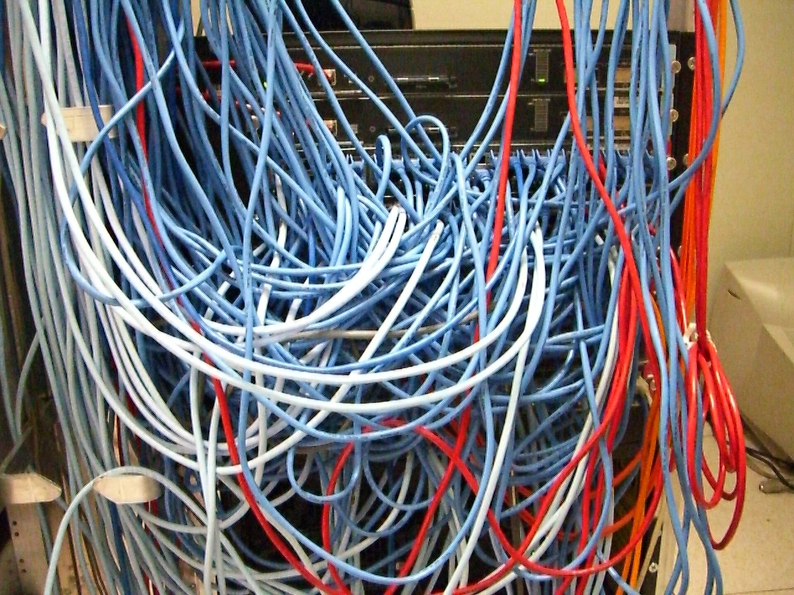 A server rack crowded with a tangled mass of network cables