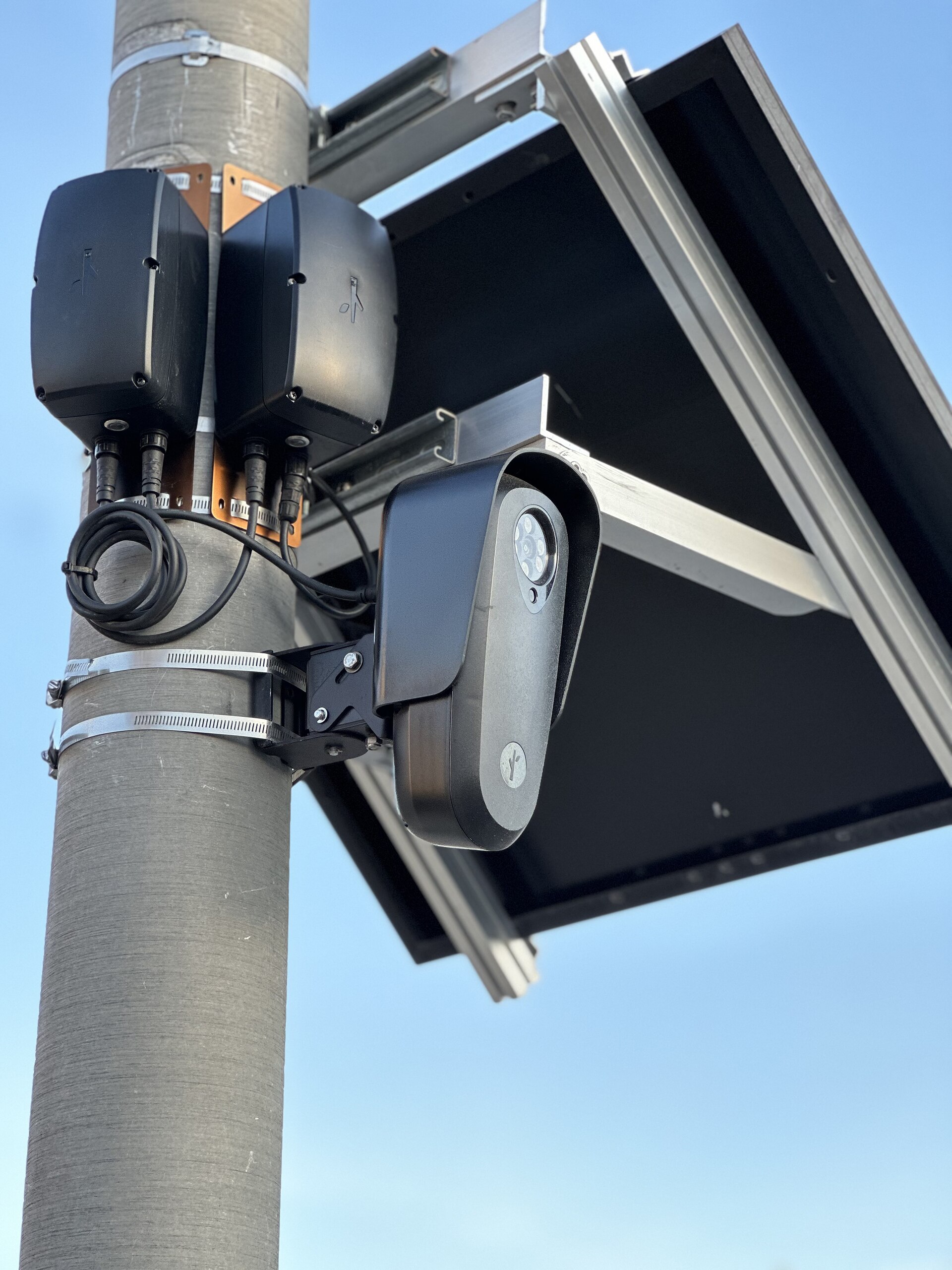 Close view of a Flock camera and solar panel mounted on a utility pole