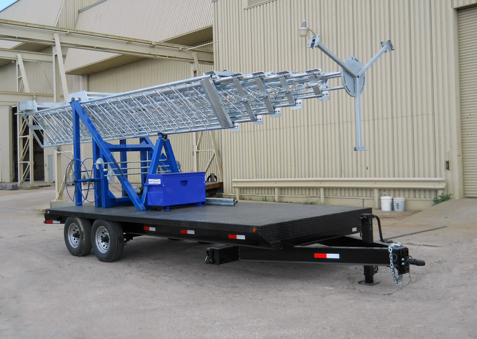 Trailer-mounted mobile cellular tower with its antenna mast lowered