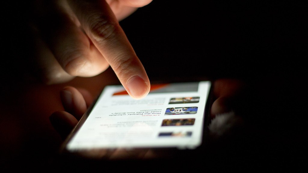 A person scrolling through news on a smartphone